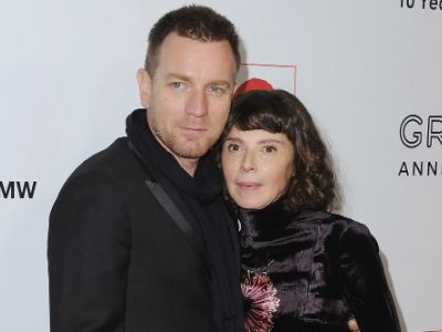 Both Ewan McGregor and Eve Mavrakis are wearing black clothes as they are side-hugging each other.